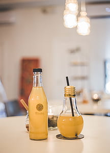 two yellow juice in bottle on table thumbnail