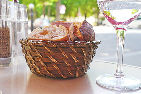 sliced bread on brown wicker basket beside clear wine glass thumbnail