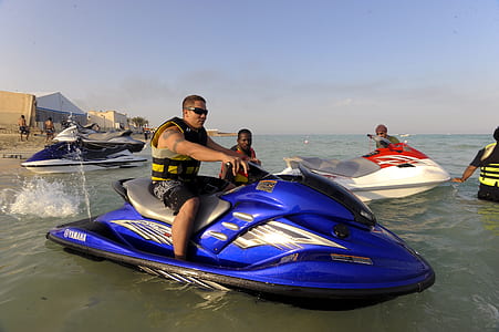 man riding on blue personal watercraft at daytime thumbnail