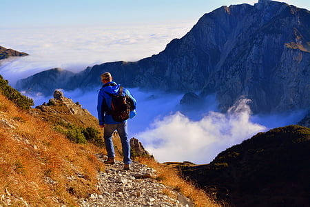 man walking on mountain during daytime thumbnail