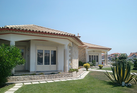white concrete house surrounded with plants thumbnail