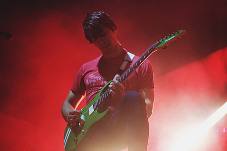A man playing a guitar on-stage at a music concert thumbnail