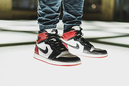 person in pair of white-black-and-red Air Jordan 1's standing on the floor thumbnail