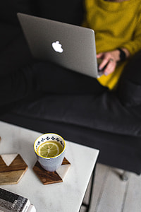 Young woman sitting on the sofa and working on her laptop thumbnail