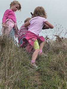 three children standing on grass during daytime thumbnail