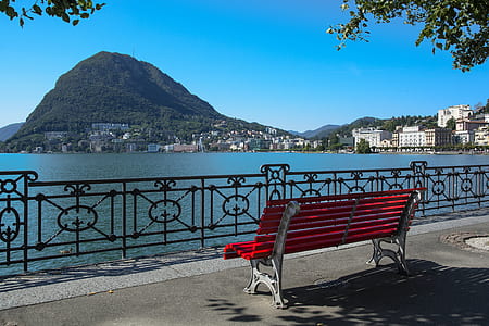 red wooden bench with white metal frame near fence thumbnail