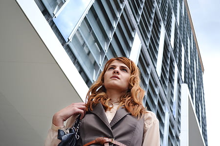 woman near white and grey concrete building during daytime thumbnail