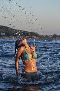 woman wearing blue bikini on body of water thumbnail
