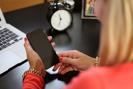 woman holding black Android smartphone thumbnail