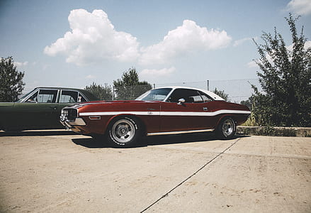 red and white muscle car parked on pavement during cloudy day thumbnail