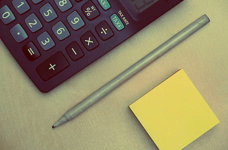 gray pen beside calculator and yellow sticky note thumbnail