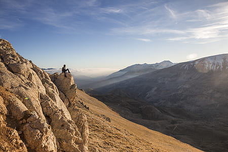 man sitting on rocky mountain thumbnail