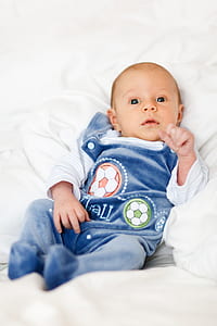 baby lying on white textile thumbnail
