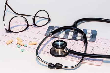 black stethoscope and eyeglasses on white surface thumbnail
