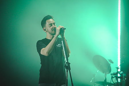 Man Wearing Black Crew-neck T-shirt Holding Microphone thumbnail