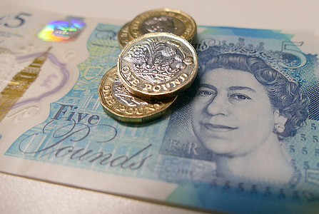 four 2-toned coins on top of 5 banknote thumbnail