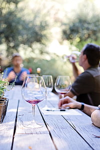 three wine glasses on gray wooden picnic table thumbnail