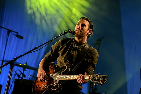 man playing electric guitar white singing on stage thumbnail