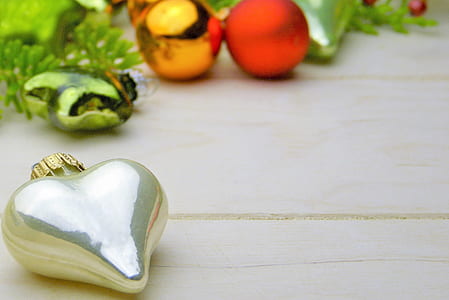 silver heart Christmas bauble on beige wooden surface thumbnail