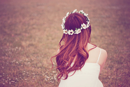woman in white camisole and white floral headband looking on field taking picture of back thumbnail