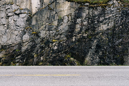 empty concrete road near gray mountain thumbnail