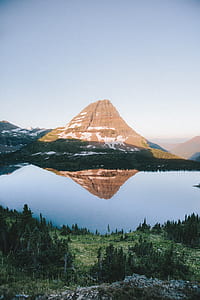 brown mountain with green trees during daytime thumbnail