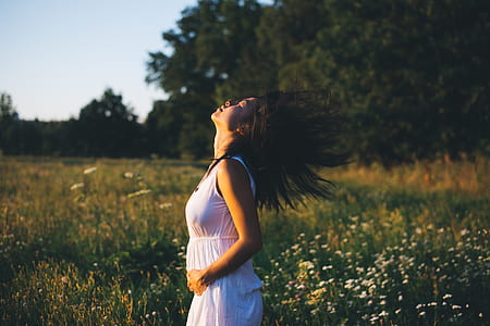 woman shipping hair in grass field thumbnail