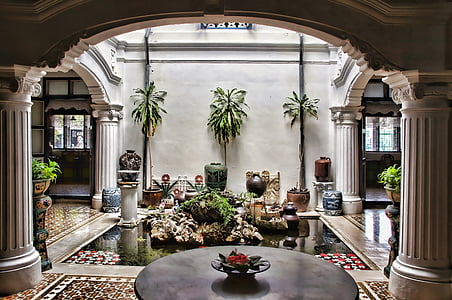 indoor fountain near wall with green plants and vases thumbnail