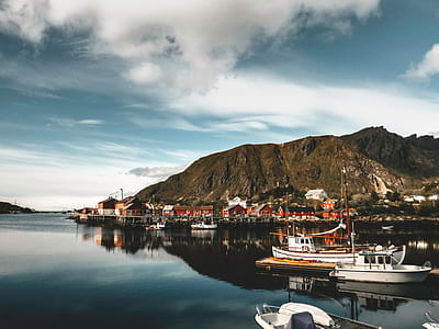 photography of white boat next to brown mountain thumbnail