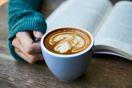 person holding white ceramic mug with coffee latte thumbnail