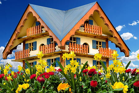 beige and orange house surrounded by flowers thumbnail