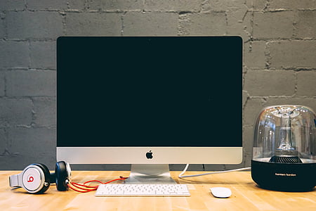 silver iMac beside white Beats by Dr.Dre over-ear headphones thumbnail