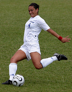 woman in white soccer jersey kicking ball thumbnail
