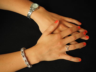 woman wearing round silver-colored analog watch, silver-colored link bracelet, and silver-colored cursive love ring thumbnail