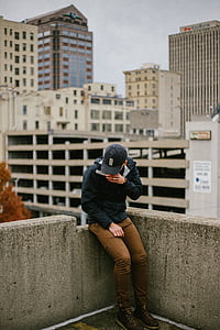 man sitting on building edge thumbnail
