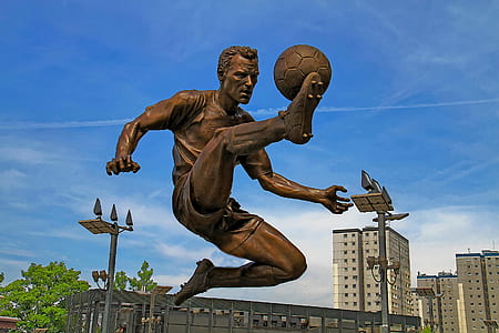 man kicker soccerball statue under cloudy sky day thumbnail