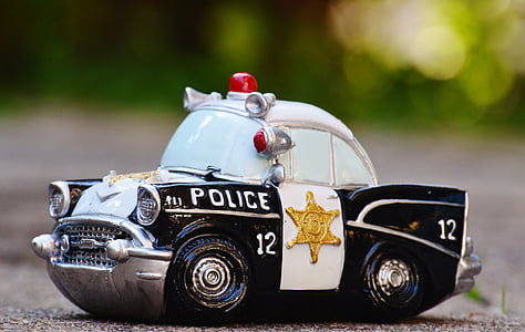 selective focus photography of white and black police car scale model on pavement thumbnail