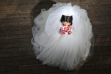 woman in white bridal gown holding bouquet of flowers thumbnail