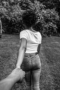 woman in shirt and fitted jeans standing on green grass field thumbnail