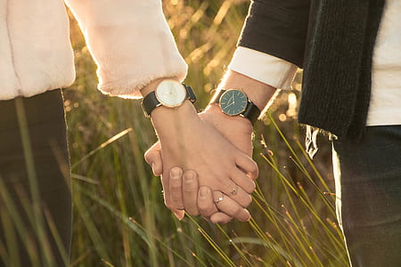 two person holding their hands while standing on grass field thumbnail