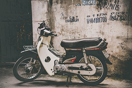 underbone motorcycle parked beside building at daytime thumbnail