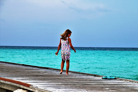 girl standing on brown wooden dock thumbnail
