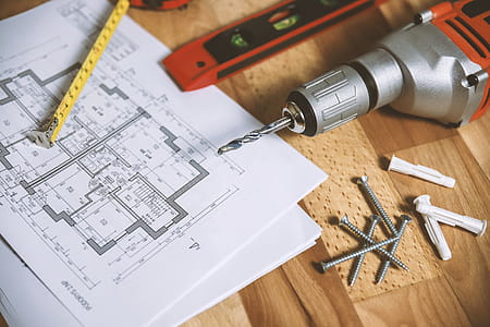 Closeup drill tool on wood background with plans for the apartment thumbnail