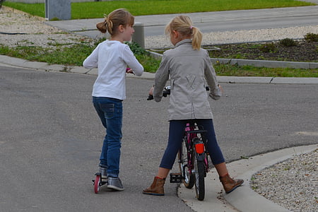 girl riding bicycle and kick scooter on road thumbnail