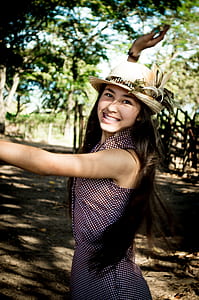 girl in white and black sleeveless dress and white hat thumbnail