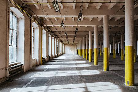 Interior of an abandoned building hall with yellow pillars thumbnail
