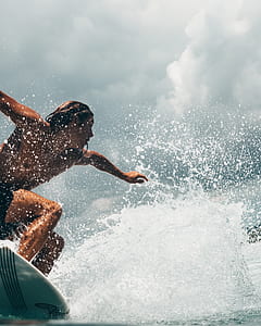 man riding on blue surfboard thumbnail