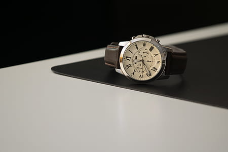 white analog watch on white and black table thumbnail