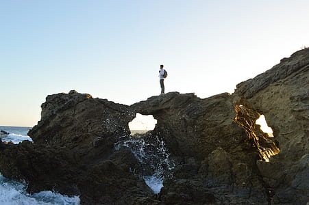 man in white top standing on rack beside beach thumbnail