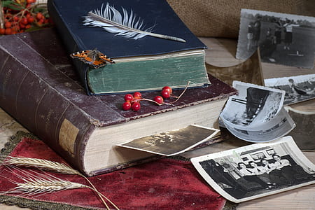 two hardbound books near photographs thumbnail